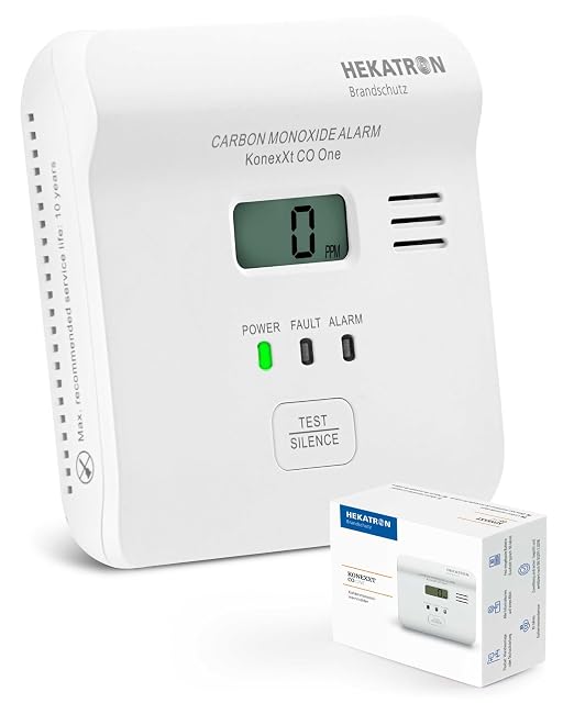 White Hekatron KonexXt CO One carbon monoxide alarm with a display, mounted flat on a wall